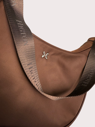 up close image of emmy bag in chestnut with metal logo