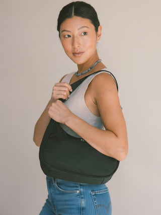 Black Emmy Bag being worn like a small hobo bag purse over the shoulder